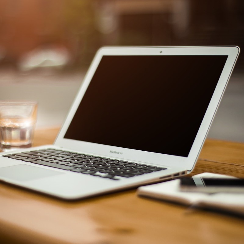 a white laptop resting on the table.