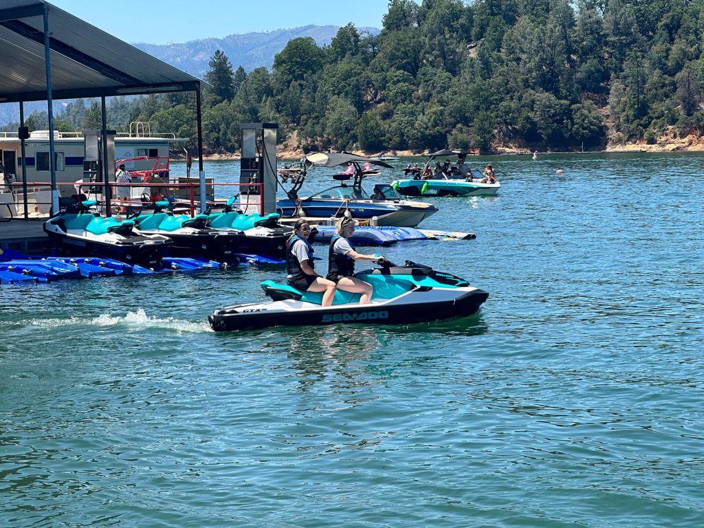 two individuals enjoying a boat ride on a rental Seadoo at Bridge Bay, Shasta Lake.
